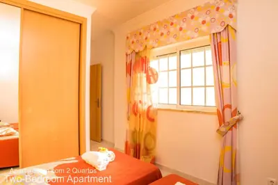 a bedroom with a window and a bed and a curtain at Akisol Albufeira Ocean II in Albufeira