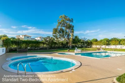 an image of two pools in a yard with trees at Akisol Albufeira Ocean II in Albufeira