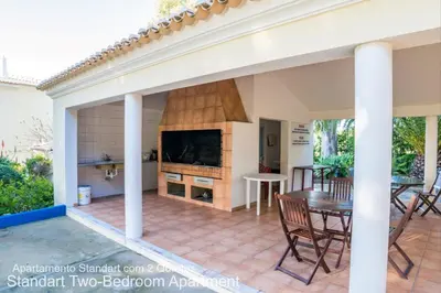 a patio with a fireplace and a table and chairs at Akisol Albufeira Ocean II in Albufeira
