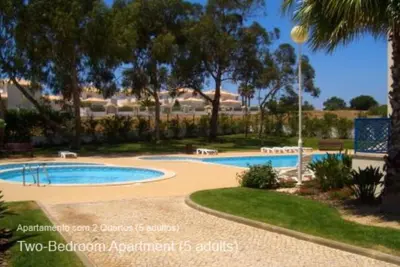 a swimming pool in a resort with trees at Akisol Albufeira Ocean II in Albufeira