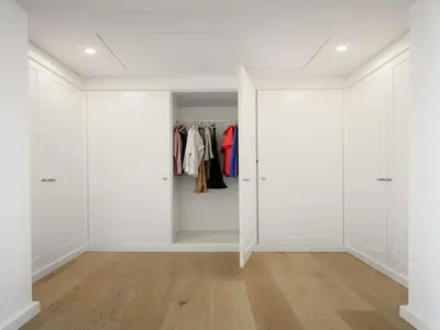 a white walk in closet with white walls and wood floors at Contemporary Vilamoura Villa Stunning Open Plan Design Villa Azure Elegance in Quarteira