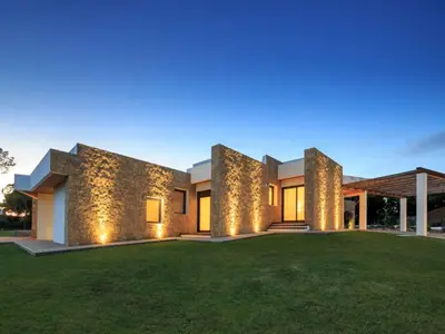 a large house with a lawn in front of it at Contemporary Vilamoura Villa Stunning Open Plan Design Villa Azure Elegance in Quarteira