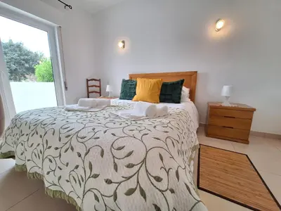 a bedroom with a large bed and a window at Espaçoso apartamento com excelente espaço exterior in Albufeira