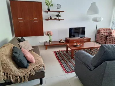 a living room with a couch and a tv at Espaçoso apartamento com excelente espaço exterior in Albufeira