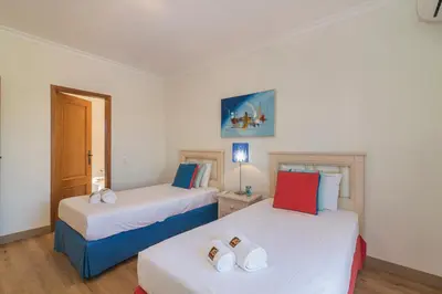 two beds in a room with white walls at Vilamoura - VILLA VINTE in Vilamoura