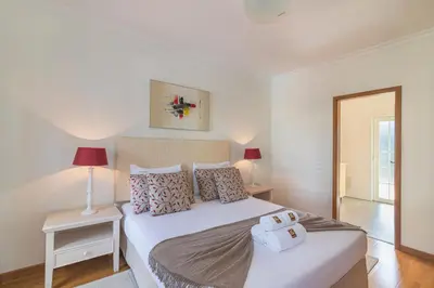a bedroom with a large white bed and two lamps at Vilamoura - VILLA VINTE in Vilamoura