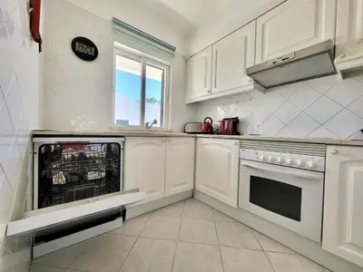 a kitchen with white cabinets and a dishwasher at Albufeira Balaia Golf Vilage 4 With Pool by Homing in Albufeira