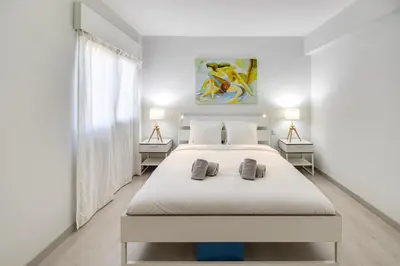 a white bedroom with a large bed and two lamps at Lovely 3BD 150m Beach Ocean View AC Wi-Fi Balcony in Albufeira