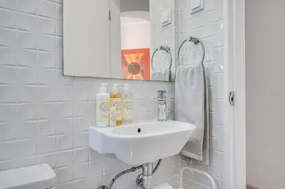 a white bathroom with a sink and a mirror at Lovely 3BD 150m Beach Ocean View AC Wi-Fi Balcony in Albufeira