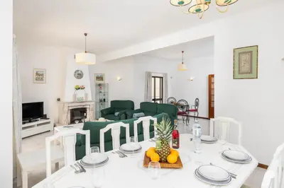a living room with a table and a couch at Villa Cavaco in Vilamoura