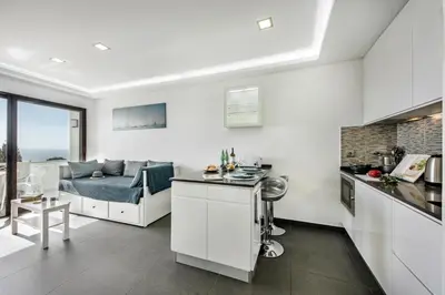 a white kitchen and living room with a couch at Lagoon Bleue in Albufeira
