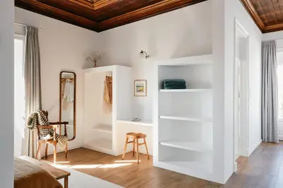 a bedroom with white walls and a wooden ceiling at Solar do Bisavô in Bordeira