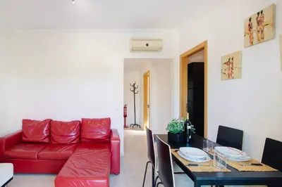 a living room with a red couch and a table at Algarve Paraíso - Monte da Balaia in Olhos de Água