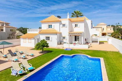 a villa with a swimming pool in front of a house at Villa Marlene in Guia