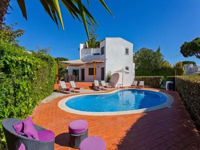 a swimming pool in front of a house at Charming Vilamoura Villa Short Walk To Marina Villa O Clube 3 Bedrooms in Quarteira