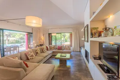a living room with a couch and a tv at Villa Adelaide in Quarteira