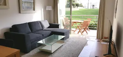 a living room with a couch and a glass table at Encosta Da Orada in Albufeira