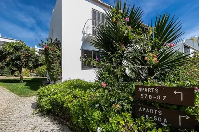 a sign in front of a building with flowers at Apartment in São Rafael Albufeira Beach Resort in Albufeira
