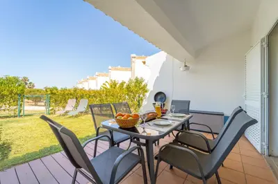 a dining table and chairs on a patio with a view at Villa Periquito 2BD Pool Fast WiFi AC Garden in Albufeira