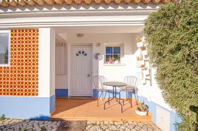 a patio with chairs and a table in a house at Villa Periquito 2BD Pool Fast WiFi AC Garden in Albufeira