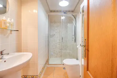a bathroom with a shower and a sink and a toilet at Villa Periquito 2BD Pool Fast WiFi AC Garden in Albufeira