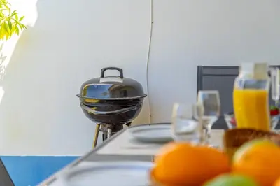 a grill sitting on top of a table with oranges at Villa Periquito 2BD Pool Fast WiFi AC Garden in Albufeira