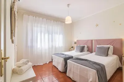 two beds in a room with white and pink at Vilamoura M.M. Holidays T2 in Vilamoura