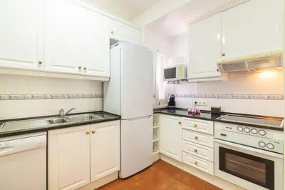 a white kitchen with white cabinets and a sink at Vilamoura M.M. Holidays T2 in Vilamoura