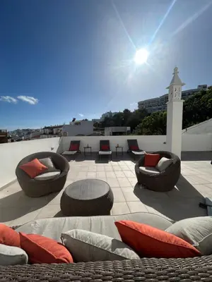 a patio with chairs and a table on a roof at Boutique Style Town House in Albufeira