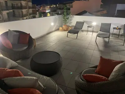 a rooftop patio with chairs and a table and chairs at Boutique Style Town House in Albufeira