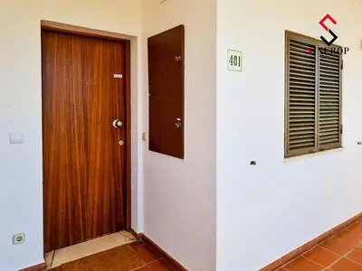 a hallway with a wooden door and a window at Apartamento T1 - Valmangude in Albufeira