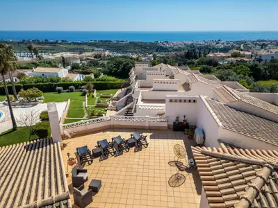a swimming pool in front of a building with palm trees at Apartment Aguia M T2 - VIP Properties by Interhome in Albufeira