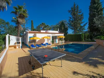 a pool with a ping pong table in front of a house at Villa Maria by Interhome in Albufeira