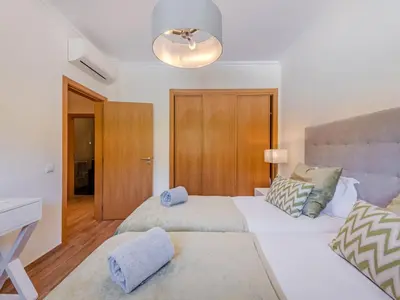 a bedroom with a large bed with towels on it at Apartment Jardins Marina T2 - VIP Properties by Interhome in Albufeira
