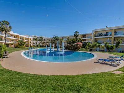 a white chair sitting in the middle of a swimming pool at Apartment Jardins Marina T2 - VIP Properties by Interhome in Albufeira