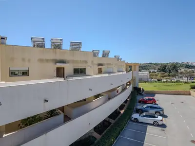 a large swimming pool with an umbrella in the middle at Apartment Jardins Marina T2 - VIP Properties by Interhome in Albufeira