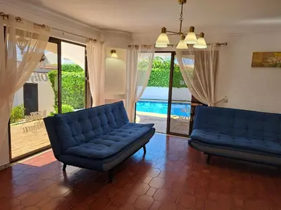 a living room with two blue couches and a pool at Villa Libertos V4 - VIP Properties by Interhome in Albufeira