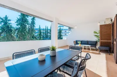 a dining room with a table and chairs and a large window at Balaia apartment at Albufeira in Albufeira