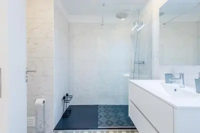 a white bathroom with a sink and a shower at Balaia apartment at Albufeira in Albufeira