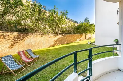 two chairs sitting on the grass on a balcony at BeGuest Falesia Beach & Garden in Albufeira