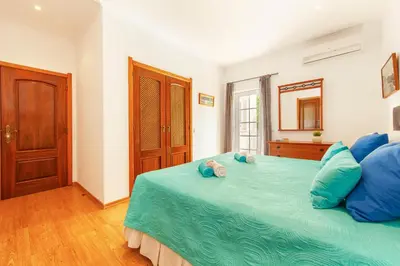 a bedroom with a large bed with blue pillows at Villa Las Palmas by Algarve Vacation in Albufeira