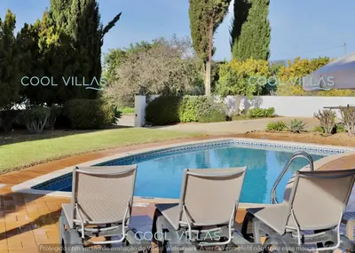 a swimming pool with two chairs and an umbrella at Orquidea Senses - 6 Pax - Sea View in Albufeira