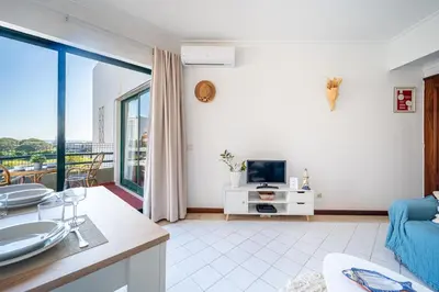 a living room with a couch and a tv at Vilamoura Sea View in Vilamoura