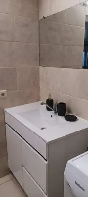 a kitchen with a microwave and a washing machine at Apartment near the ocean Rua 5 de Outubro in Albufeira