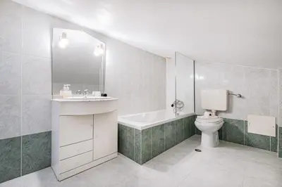 a white bathroom with a sink and a toilet at Apart Ocean View in Albufeira