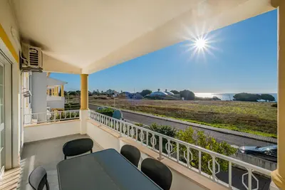 a balcony with a table and chairs and a view of a road at Apart Ocean View in Albufeira