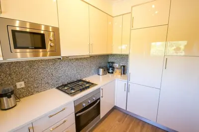 a kitchen with white cabinets and a stove top oven at Sir Anthony Luxury in Albufeira