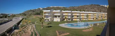 a large building with a pool in front of a mountain at Sir Anthony Luxury in Albufeira