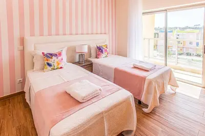 two beds in a room with a window at Sir Anthony Luxury in Albufeira