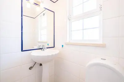 a white bathroom with a sink and a toilet at Villa Ventura Heritage in Albufeira